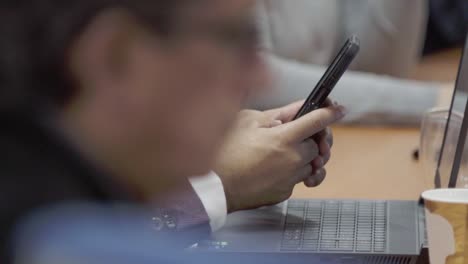 Individual-using-his-phone-during-an-executive-meeting