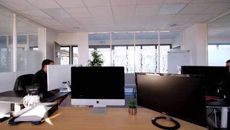 Modern-open-office-space-with-computer-workstations-and-glass-partitions