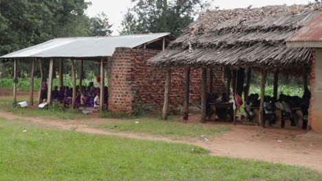 Children-in-front-of-a-rural-outdoor-school-in-Uganda,-Africa