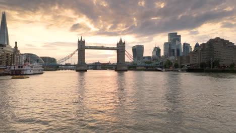 Drone-push-in-over-River-Thames-in-London-at-sunset-toward-famous-Tower-Bridge