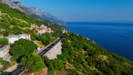 Drone-tracking-cars-on-the-Makarska-riviera-coastline-in-Croatia,-summer-day