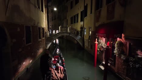 Romantic-holiday-destination-Venice-Italy-at-night,-gondola-passing-on-water-canal