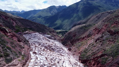 Salt-Mines-of-Maras-in-the-Sacred-Valley-of-Peru,-panoramic-aerial-overview-of-valley-with-pools