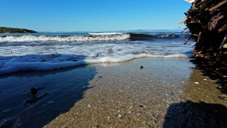 Sea-waves-flowing-over-sandy-Greek-coastline,-motion-view