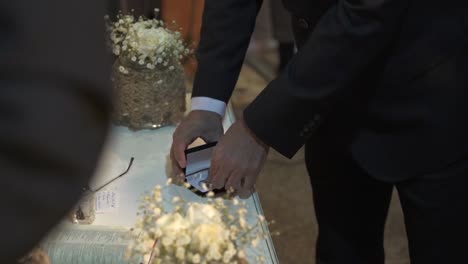 Man-taking-out-engagement-ring-from-a-box-during-wedding-event-with-camera-flash
