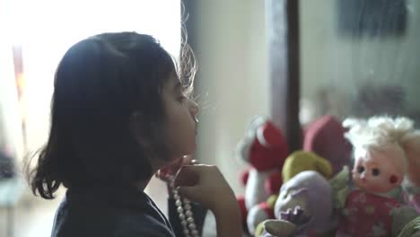 Closeup-view-of-a-girl-playing-with-her-doll-inside-her-house