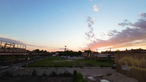 FPV-aerial-drone-footage-of-a-drone-taking-flight-into-the-air-in-the-Chicago-urban-aera-during-sunset-next-to-the-train-station