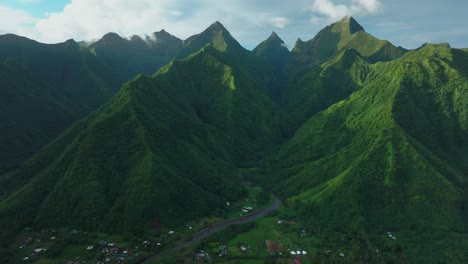 Late-afternoon-sunset-green-island-mountain-peaks-Teahupoo-Tahiti-French-Polynesia-aerial-drone-town-village-Paris-summer-Olympics-venue-Mount-Orohena-Aorai-Ronui-blue-sky-river-valley-forward-pan-up