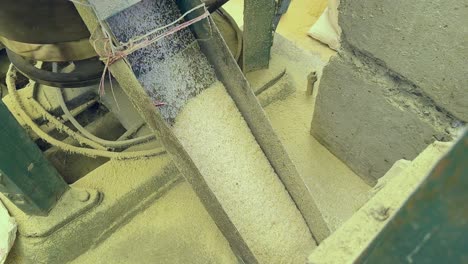 Wide-shot-of-Freshly-milled-rice-is-coming-out-of-the-rice-milling-machine