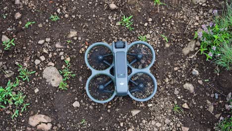 Top-down-view-of-FPV-drone-take-off-maneuver-from-brown-ground,-Czechia