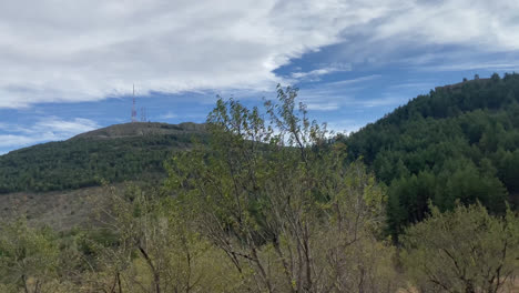 Beautiful-shot-through-the-side-window-of-a-moving-car-of-a-landscape-with-trees-and-beautiful-vegetation-on-the-way-to-a-village-in-Spain-in-the-afternoon