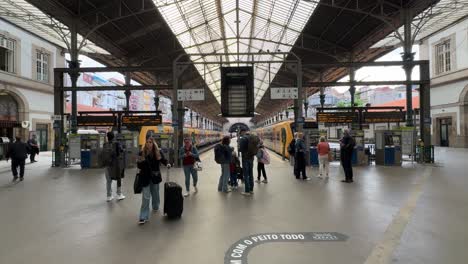 Punto-De-Vista-De-Los-Turistas-Caminando-Y-Comprobando-El-Tiempo-De-Los-Trenes-En-La-Estación-De-Tren-De-Sao-Bento-En-Oporto,-Portugal.