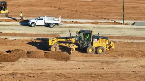 Niveladora-Y-Cargador-Frontal-Moviendo-Montones-De-Tierra-Fresca-Alrededor-De-Un-Nuevo-Sitio-De-Construcción-Residencial