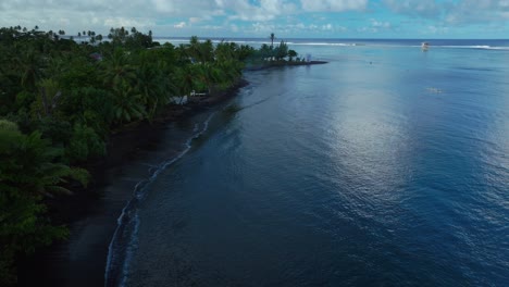 Beach-coastline-Teahupoo-Tahiti-French-Polynesia-aerial-drone-sunny-morning-Point-Faremahora-coral-reef-channel-surf-wave-judge-tower-Paris-2024-Summer-Olympics-venue-boat-blue-sky-forward-pan-motion