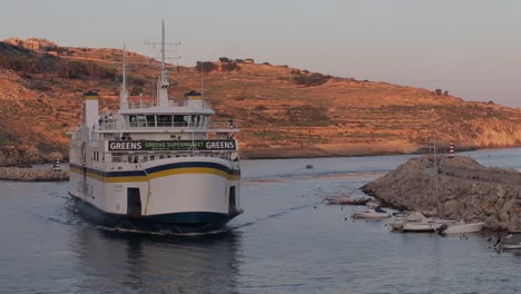 A-ferry-boat-enters-Gozo's-Bay-in-Malta,-embodying-the-spirit-of-nautical-adventure-and-the-tranquil-beauty-of-coastal-life