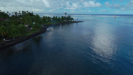 Kayak-boats-Teahupoo-Tahiti-French-Polynesia-aerial-drone-sunny-morning-Point-Faremahora-coastline-coral-reef-channel-surf-wave-judge-tower-Paris-2024-Summer-Olympics-venue-boat-blue-sky-circle-right