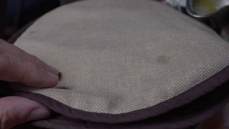 Hand-Opens-Tortilla-Warmer-Pouch-with-stack-of-Tortillas-Inside,-close-up