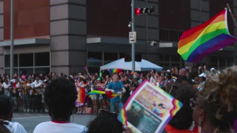 People-wave-Pride-flags-during-parade-and-celebration-in-Houston,-Texas