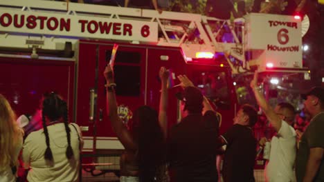 Fire-truck-rides-on-route-in-Pride-parade-celebration-at-night-in-downtown-Houston,-Texas