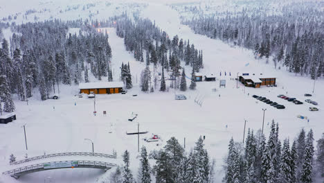 Aerial-tracking-shot-of-the-ski-area-and-slopes-of-Luosto-fell,-winter-in-Lapland