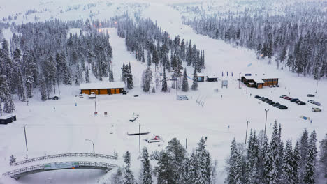 Toma-Aérea-De-Seguimiento-De-La-Zona-De-Esquí-Y-Las-Pistas-De-Luosto,-Invierno-En-Laponia.