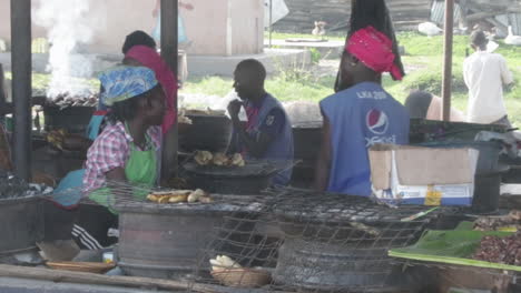 Street-food-sellers-in-Uganda-preparing-food,-handheld-view