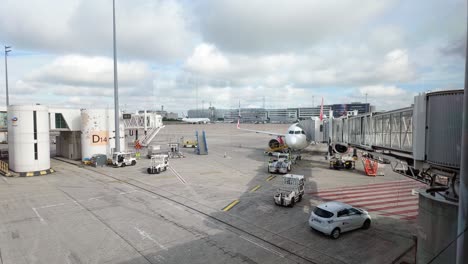 Ready-to-take-off-aircraft-awaits-the-passengers-connected-to-the-boarding-bridge-at-the-Charles-de-Gaulle-International-Airport-Terminal-2-in-Paris,-France