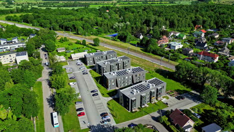 Drone-shot-of-city-area-with-apartments-nearby-green-forests-in-Keila,-Estonia-slow-motion