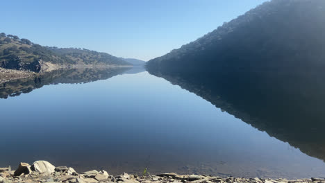 Beautiful-shot-of-a-stunning-lake-located-between-mountains-in-Ribera-del-Duero-in-Spain-at-daylight