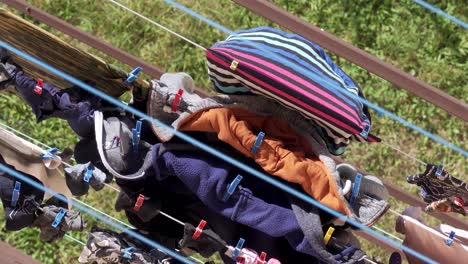 Laundry-drying-on-clothes-dryer,-top-view-with-slight-wind