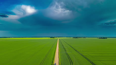 Aerial-drone-hyperlapse-shot-of-rainstorm-cloud-movement-over-green-farmlands-on-a-cloudy-day