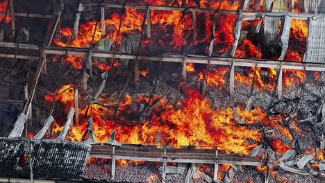 Top-aerial-view-of-raging-flames-ravaging-a-warehouse-in-industrial-area