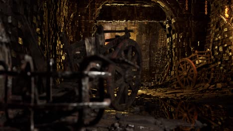 Scary-dark-dungeons-with-stone-walls,-old-barrels,-chains,-car-wheels,-old-wagon,-3D-animation-camera-dolly-right