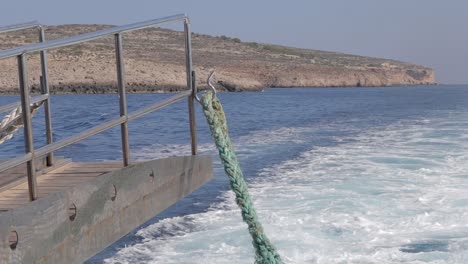 Sea-water-splashes-behind-the-ferry-near-the-coastline-of-Malta,-encapsulating-the-essence-of-maritime-travel-and-exploration