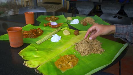 Asian-man-eating-south-Indian-food-served-on-fresh-banana-leaf-at-a-local-south-Indian-restaurant