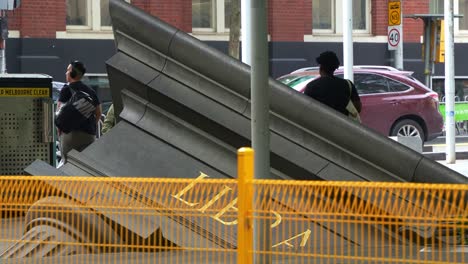 The-Architectural-Fragment-sculpture-by-Petrus-Spronk-on-Swanston-Street,-symbolising-the-downfall-of-civilisation,-on-the-pavement-outside-of-State-Library-Victoria,-landmark-of-Melbourne-city