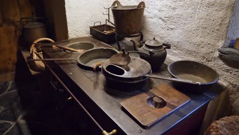 A-shoot-of-a-wood-stove-with-pans-on-it,-inside-a-house-from-the-1800s