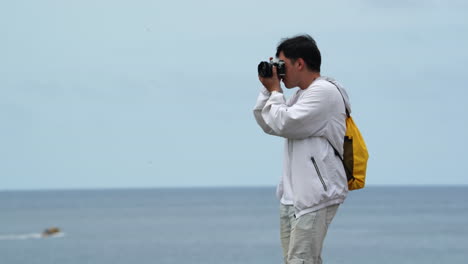 Man-Taking-Photos-Of-Sea-With-Digital-Camera---Wide-Shot