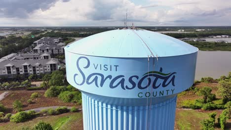 Drohnenaufnahme-Zeigt-Turm-Mit-Visit-Sarasota-County-Font-In-Florida