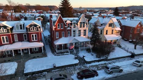 Snowy-houses-with-american-flag-during-golden-sunset-in-winter