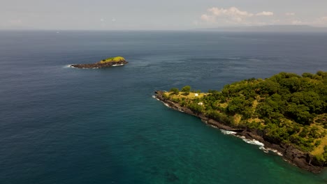 Aerial-drone-footage-captures-Bukit-Asah-peninsula's-beauty-and-Kuan-Island-in-Karangasem,-Bali