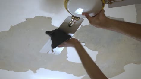 Closeup-of-South-Asian-man-cleaning-ceiling-fan-of-bedroom