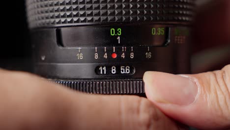 Closeup-shot-Lens-aperture-stop-hands-turning-vintage-camera-lens-focus-ring