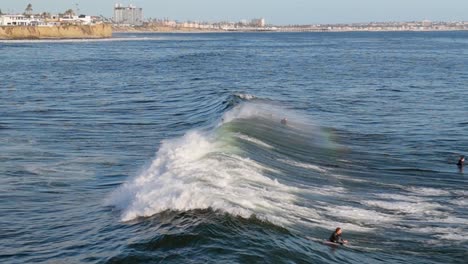 Adventurous-Surfers-Over-Huge-Swell-In-The-Ocean-Near-Bird-Rock-Seaside-Neighborhood-In-San-Diego,-California-USA