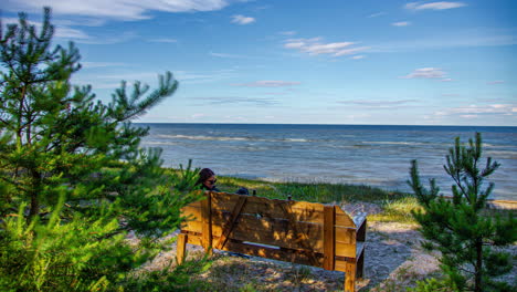 Young-couple-on-a-park-bench-overlooking-the-sea---time-lapse