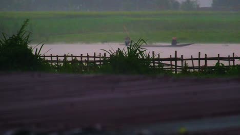 Rural-People-Travel-by-Boat-Along-the-Flooded-River,-Gliding-Over-Inundated-Farmland-and-Submerged-Rural-House-Roofs-During-the-Monsoon-Season-in-Bangladesh---Static-Shot