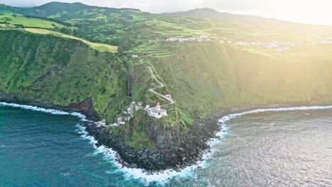 Lighthouse-on-a-cliffside-overlooking-the-ocean-at-sunrise-with-a-winding-road-leading-up