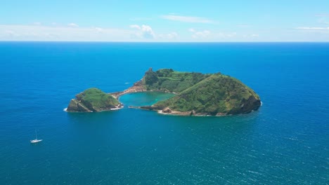 Vila-franca-islet-in-sao-miguel-with-a-sailboat-nearby,-aerial-view