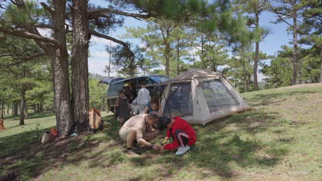 A-time-lapse-captures-a-lively-group-of-people-setting-up-a-tent-on-a-picturesque-pine-covered-hill