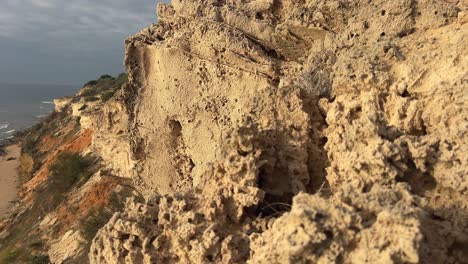 Die-Zerklüftete-Küste-Spaniens-Zeichnet-Sich-Durch-Einen-Sandstrand-Neben-Sedimentären-Klippen-Aus,-Die-Alle-Von-Der-Hellen-Tagessonne-Beleuchtet-Werden-Und-Die-Essenz-Der-Küstenschönheit-Und-Des-Naturwunders-Einfangen